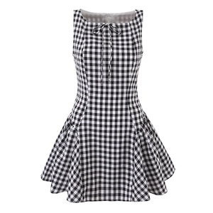 Détail d'une robe sans manches à carreaux noirs et blancs avec nœud et ourlet plissé