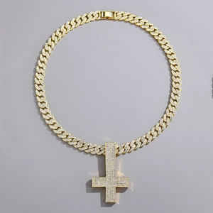 Macro shot of hip hop cross pendant and Cuban chain encrusted with shiny rhinestones