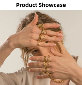 Detailed view of layered gold rings with twisted texture and link chain necklace on model