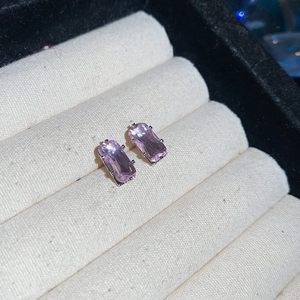 Detail of pink rectangular zircon earrings with silver four-claw setting in a jewelry box