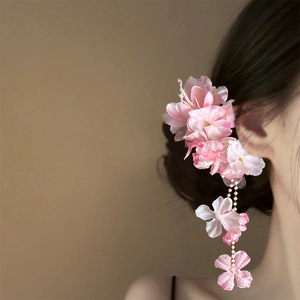 Exquisite close-up of pink floral hair clip featuring long tassel and delicate petals