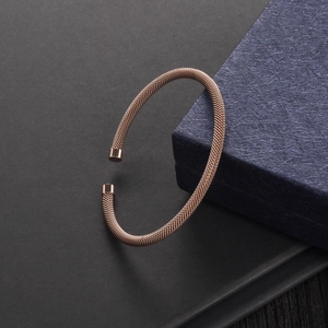 Macro detail of rose gold mesh woven cable bracelet with polished cylindrical ends