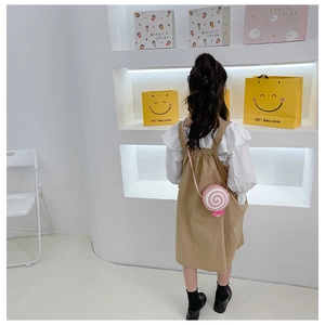 Rear view of girl wearing a pink lollipop shaped crossbody bag for kids fashion