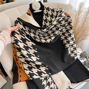 Detail of soft houndstooth scarf in black, beige, and mustard yellow with thick texture