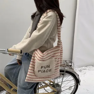 Detail of pink and white fuzzy tote bag with 'FUN PLACE' embroidery for winter