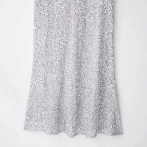 Robe de cocktail argentée à paillettes avec texture chatoyante et coupe élégante