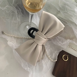 Detail of elegant champagne satin bow hair claw clip with pearls in a French style setting