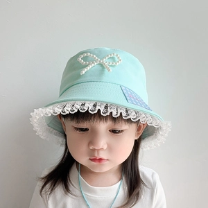 Detail of mint green sun hat with delicate white lace trim and pearl bow for children