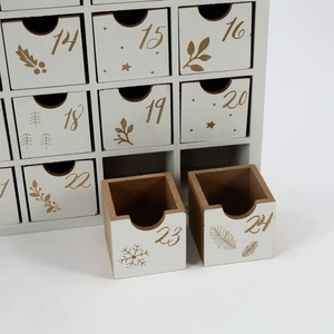 Detailed close-up of wooden advent calendar drawers with gold numbers and holiday patterns
