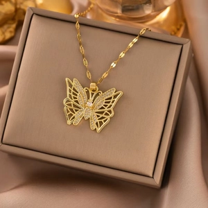 Macro shot of gold butterfly necklace pendant with zircon stones on a silk display