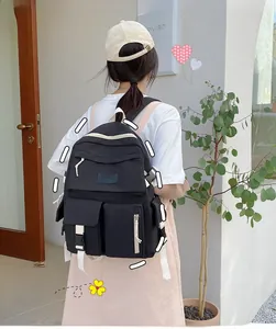 Detailed view of black nylon backpack featuring multi-pocket design and white straps