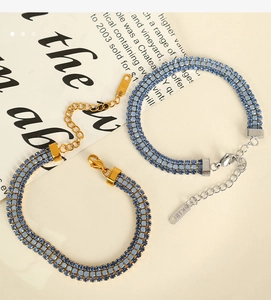 Détail de bracelets plaqués or 18 carats et argent avec trois rangées de strass bleus