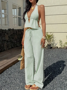Detail of light green striped halter neck top and wide-leg trousers vacation set
