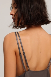 Detail of grey satin pajama top with thin double straps and smooth back silhouette