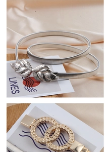 Detail of elastic metal chain belts with embossed butterfly buckle in gold and silver