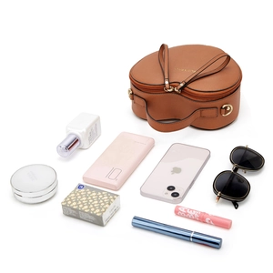 Top view of brown heart-shaped bag with storage showing phone and makeup inside