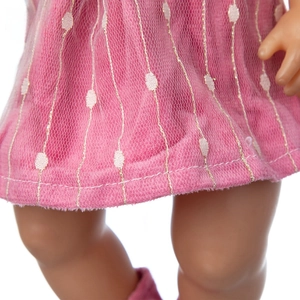 Detail of pink doll dress featuring white polka dots and gold vertical stripes on mesh