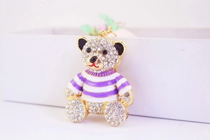 Macro shot of striped teddy bear keychain with crystal inlay and gold metal hook
