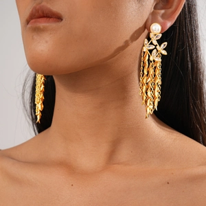 Close-up of 18K gold-plated floral earrings with pearls and long leaf tassel charms
