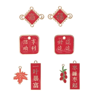 Detail shot of red enamel Christmas charms with gold borders and festive inscriptions