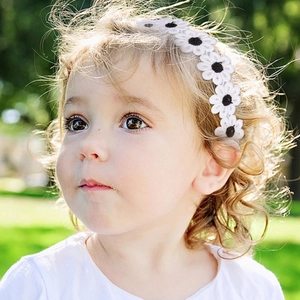 Soft elastic baby headband featuring a white daisy flower on a toddler outdoors