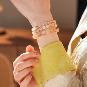 Détail de trois bracelets en perles de cristal avec dégradés d'orange et jaune