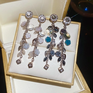 Dettaglio degli orecchini floreali con nappe e cristalli in una scatola regalo di lusso