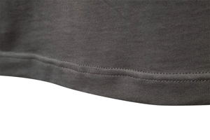 Close-up of the double-needle stitching on the hem of this dark grey cotton polo shirt