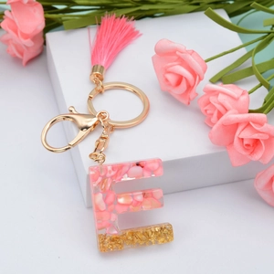 Pink resin letter E keychain with gold flakes, pink tassel and metallic hardware
