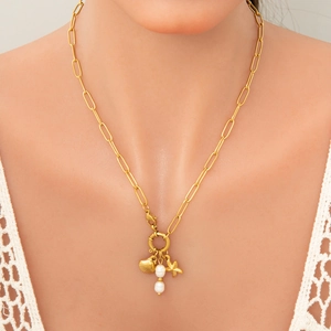 Gold paperclip link necklace with pearl, starfish and shell pendants worn by a model