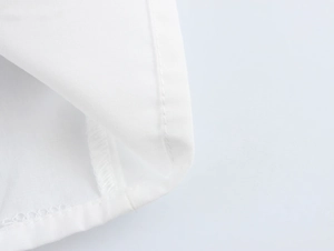Close-up of white fabric texture showing professional double-needle stitching and seams