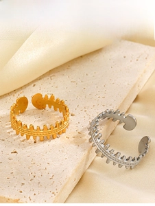 Macro detail of adjustable fishbone rings in gold and silver finish on stone