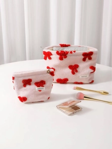 Pink plush makeup bag set with red bow accents and metal floral zipper pull
