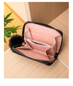 Internal detail of a black women's wallet featuring pink card slots and a zipper compartment