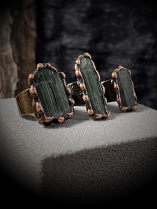 Macro detail of three raw green tourmaline stones set in vintage bronze adjustable ring