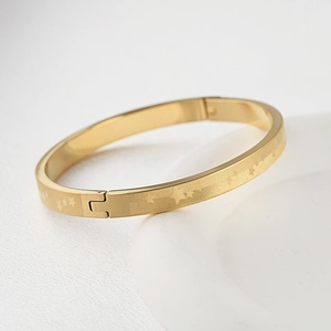 Macro di bracciale in acciaio al titanio dorato con motivi a stella e chiusura meccanica