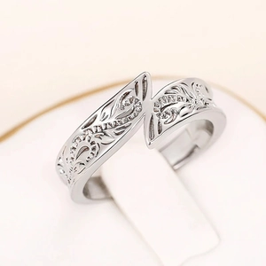 Close-up of engraved feather pattern on a vintage silver open ring with intricate details