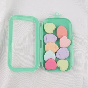 Detailed top view of 10 colorful heart-shaped makeup sponges in a mint green storage box