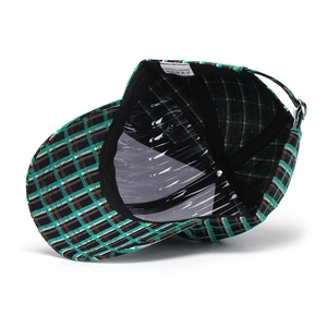 Detail view of plaid baseball cap interior showing black sweatband and 100% polyester label