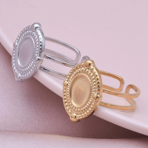 Detailed view of oval signet rings in gold and silver finish with braided edges