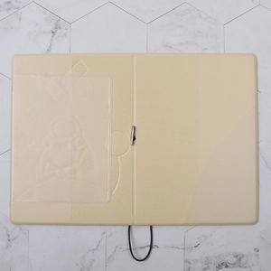 Detail of beige folding travel passport holder with astronaut embossing and strap