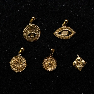 Detail of five 18k gold-plated evil eye charms for jewelry making in various designs