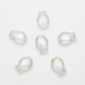 Macro view of six transparent iridescent fish-shaped crystal glass beads for DIY jewelry