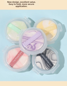 Detailed close-up of colorful mini finger makeup puffs with marble textures in storage cases