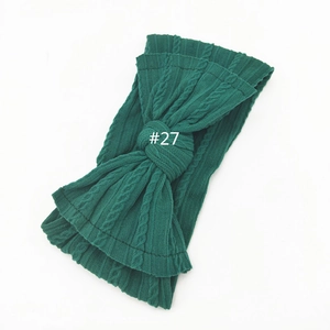 Detailed cable knit texture and large bow design on dark green nylon baby headband