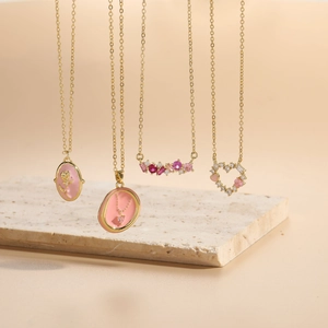 Detailed close-up of Bohemian 14K gold plated necklaces with pink zircon and enamel accents