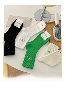 Close-up of dreamer embroidery detail on breathable cotton mid-calf socks in four colors