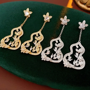 Boucles d'oreilles gourde élégantes avec fleurs en zircon en or et argent sur velours vert