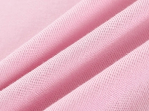 Macro shot of pink knitted fabric showing soft texture and fine ribbed details on the t-shirt