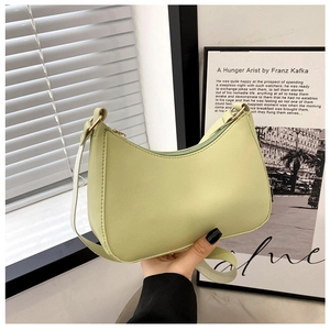 Detail of pistachio green leather underarm bag with gold ring hardware and stitching